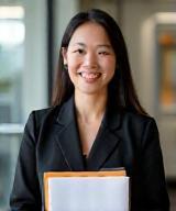 Emily Chen, Head of Project Management, smiling with project folders